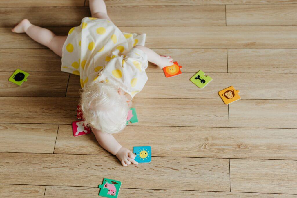 Games to play with toddlers A baby plays on the floor with puzzle pieces