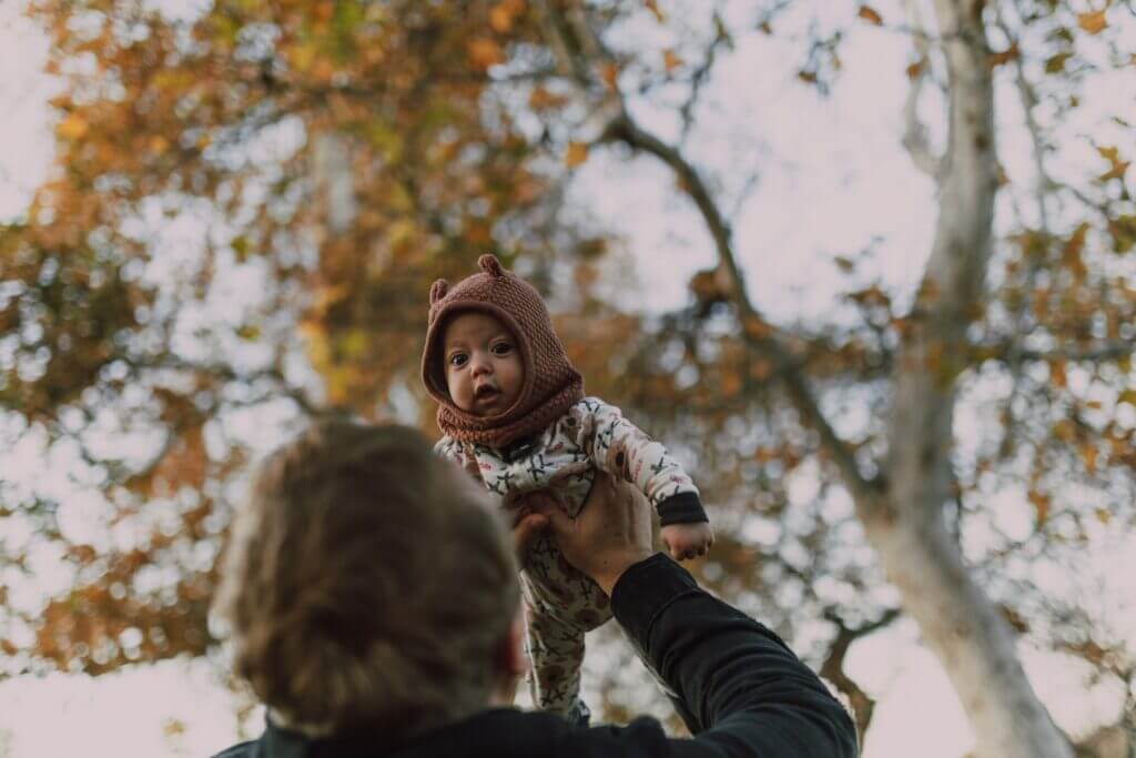 a parent throws their baby up in the air a parent throws their baby up in the air