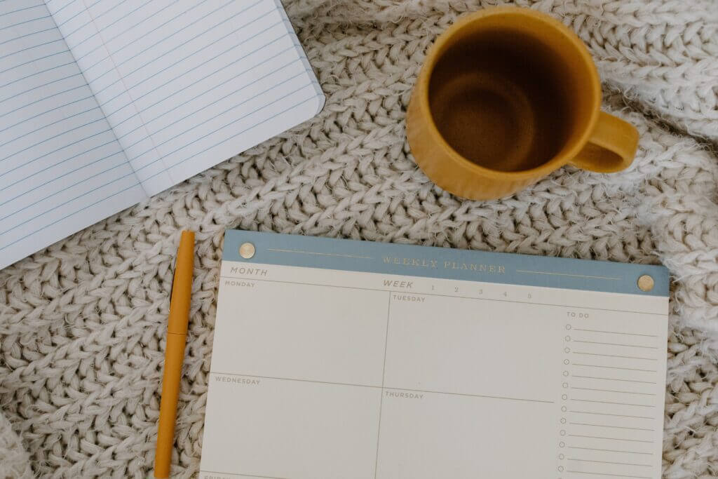 A weekly planner with a cup of coffee