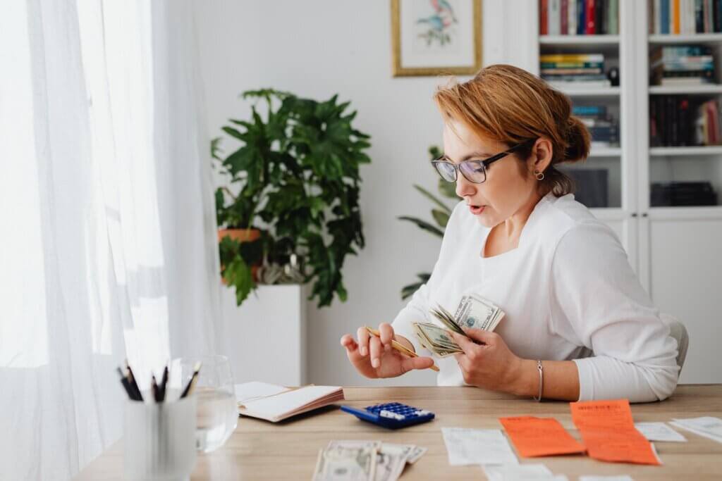Stay at home mom scheduling her life allows her time for Sitting at her Desk tallying financials for her family Stay at home mom scheduling her life allows her time for Sitting at her Desk tallying financials for her family