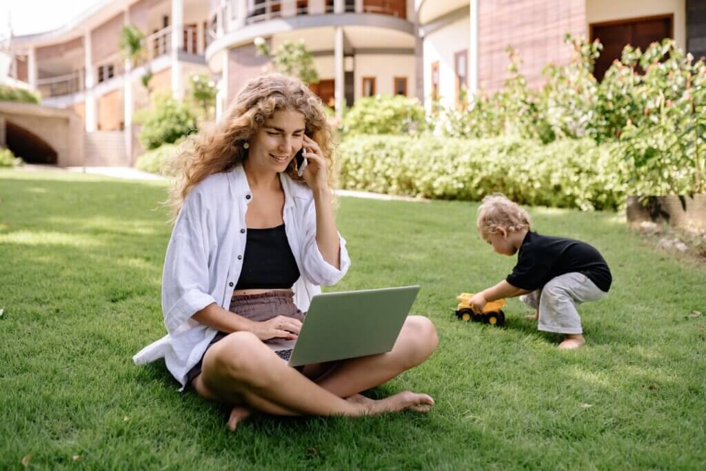 A mom working as a mortgage loan originator (a high paying job stay-at-home moms can do) while her little boy plays in the background. A mom working as a mortgage loan originator (a stay-at-home mom side hustle) while her little boy plays in the background.