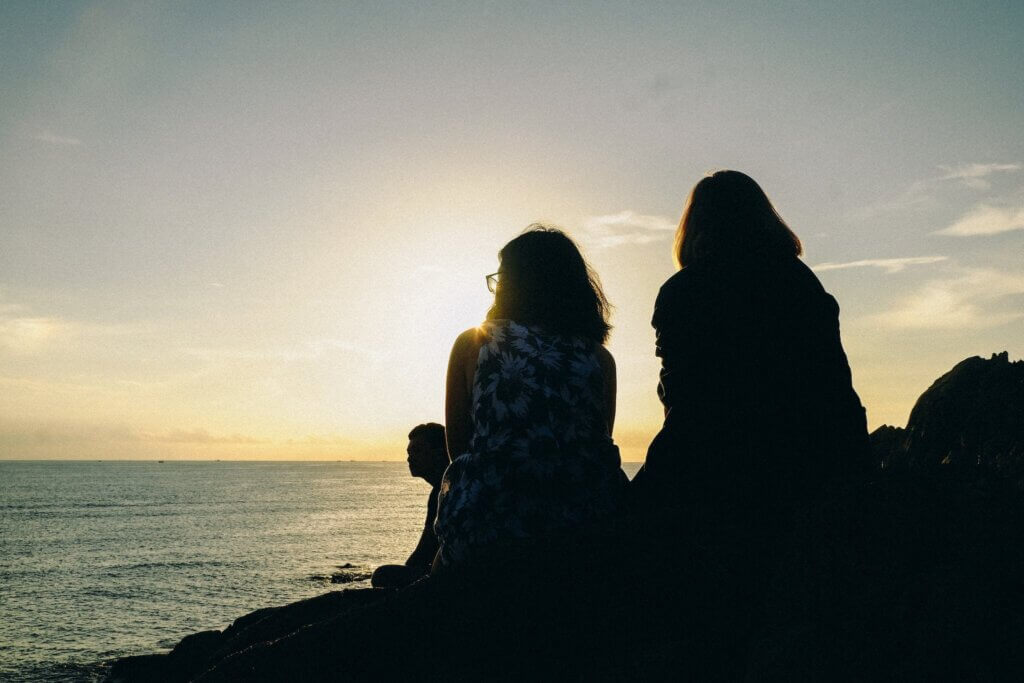 Silhouette of Two Women Facing Body of Water